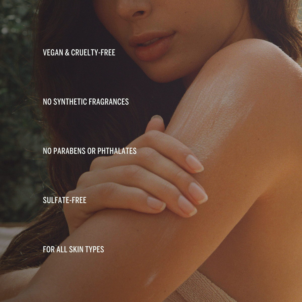 Close up of a woman smoothing body cream onto their upper arm. Text reads: Vegan and cruelty-free. 100% Natural Fragrance. No parabens or phthalates. Sulfate-free. For all skin types.